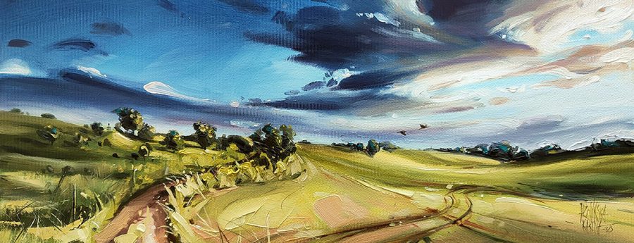 Pejzaż olejny „Mazurski klangor” Kariny Jaźwińskiej ukazujący malarskie pola i drogę wśród łagodnych wzgórz, pod impresjonistycznym niebem pełnym ruchu i światła. Obraz emanuje spokojem natury i poetyckim nastrojem charakterystycznym dla mazurskiego krajobrazu.